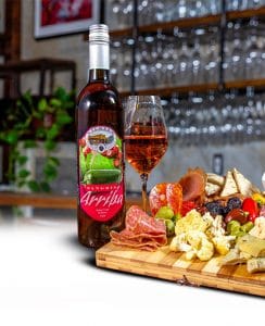 A bottle of sangria next to charcuterie that you can enjoy at our Tucson wine tasting room
