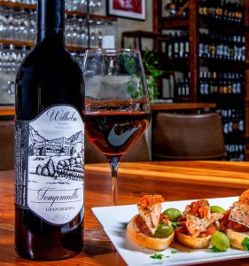 A bottle of Tempranillo wine next to tapas at our Tucson tasting room